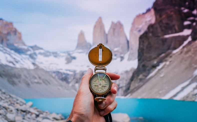 На изображении, мужчина в руках держит компас на фоне природы Чили, Чили фото