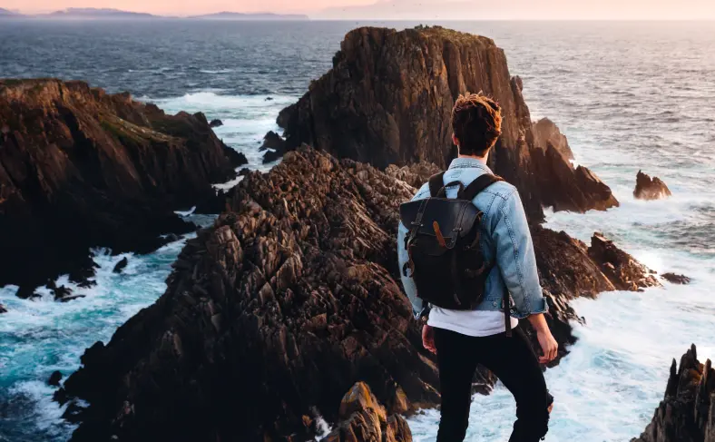 На изображении, путешественник с рюкзаком на спине смотрит на природу Ирландии, Ирландия фото