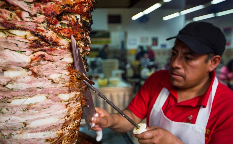 На изображении, повар-продавец нарезает мясо для приготовления блюда, Стамбул фото