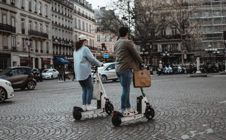 На изображении, парень с девушкой по улице Парижа едут на электросамокате, Париж фото